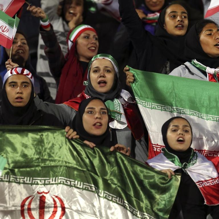 Iranische Frauen schwenken beim Spiel gegen Bolivien im Teheraner Asadi Stadion Flaggen ihres Landes.