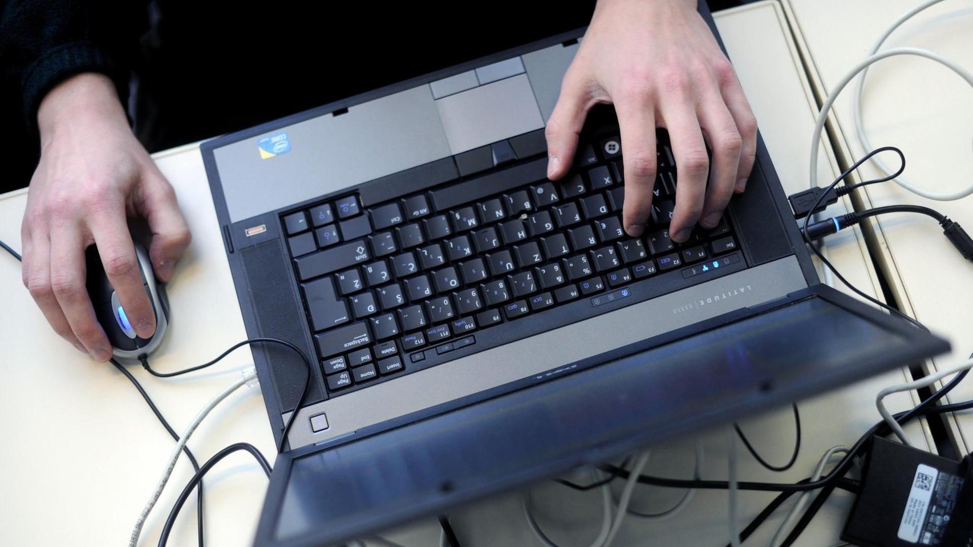 Ein User tippt auf einer Laptop-Tastatur.