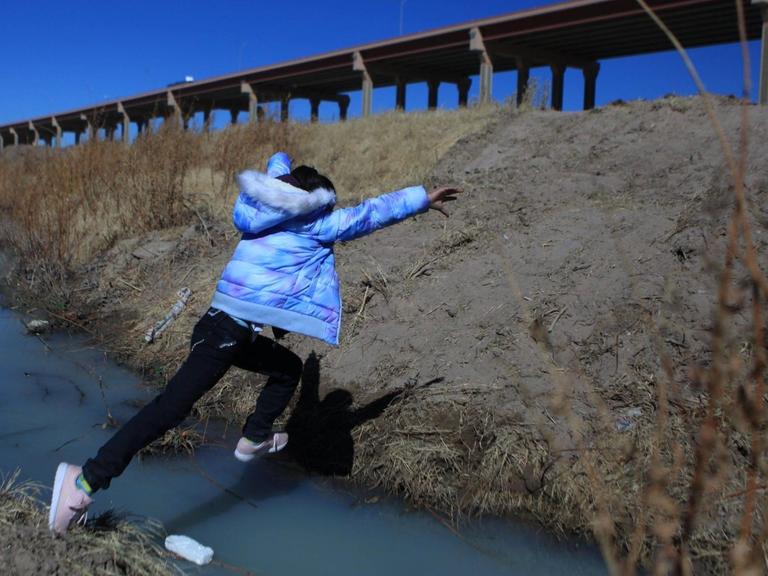 Eine Person springt über den fast ausgetrockneten Rio Grande an der Grenze zwischen den USA und Mexiko.