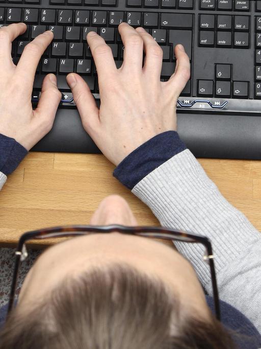 Hände liegen auf einer Tastatur und tippen etwas ein.