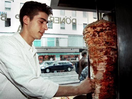 Ein Mitarbeiter einer Münchener Döner-Kebab-Imbisskette bereitet eine Portion Kebab vor