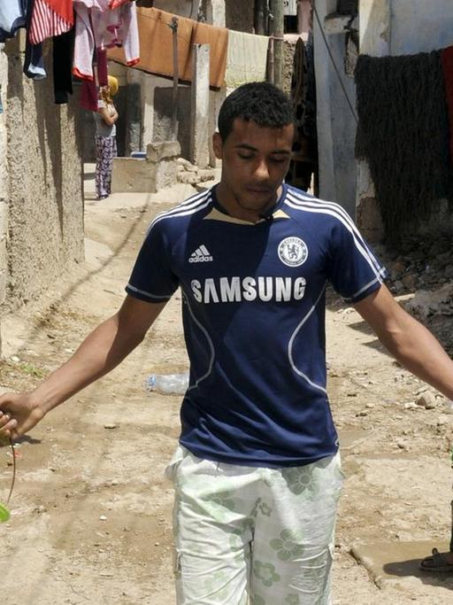 Ein Bewohner des marokkanischen Elendsviertels Sidi Moumen läuft mit Behältern an zwei Kindern vorbei.