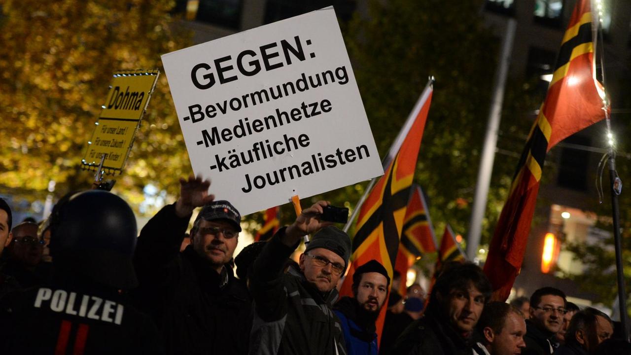 Anhänger der Pegida (Patriotische Europäer gegen die Islamisierung des Abendlandes) tragen am Abend des 26.10.2015 auf einem Marsch in Dresden Plakate mit der Aufschrift "Gegen: Bevormundung, Medienhetze, käufliche Journalisten". Anhänger der Pegida (Patriotische Europäer gegen die Islamisierung des Abendlandes) tragen am Abend des 26.10.2015 auf einem Marsch in Dresden Plakate mit der Aufschrift "Gegen: Bevormundung, Medienhetze, käufliche Journalisten".