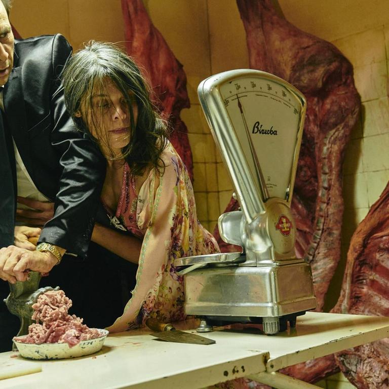 Foto von der Inszenierung: Die Hand der Schauspielerin wird durch den Fleischwolf gedreht.
