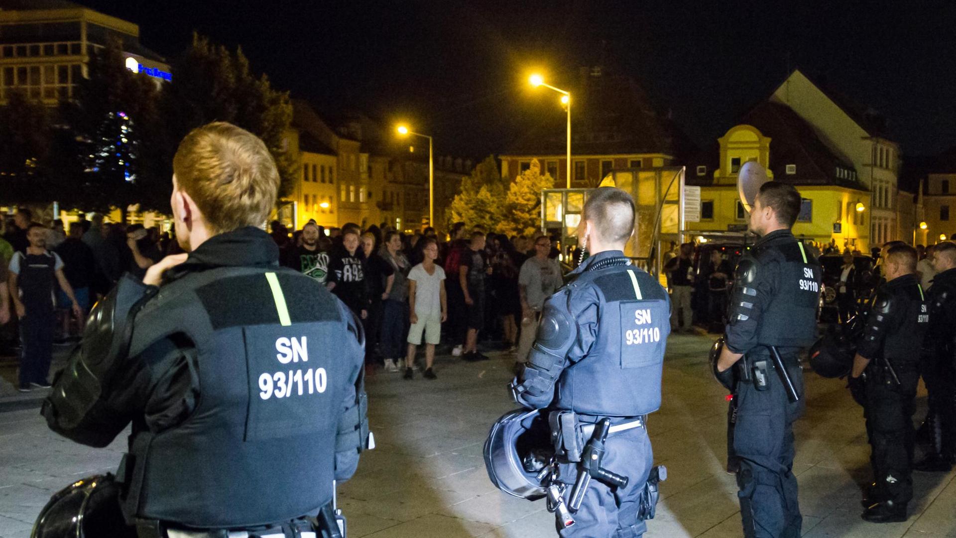 Bewaffnete Polizeibeamte stehen in Bautzen (Sachsen) auf dem Kornmarkt etwa 350 Versammlungsteilnehmern aus dem politisch rechten Spektrum gegenüber. Es ist dunkel.