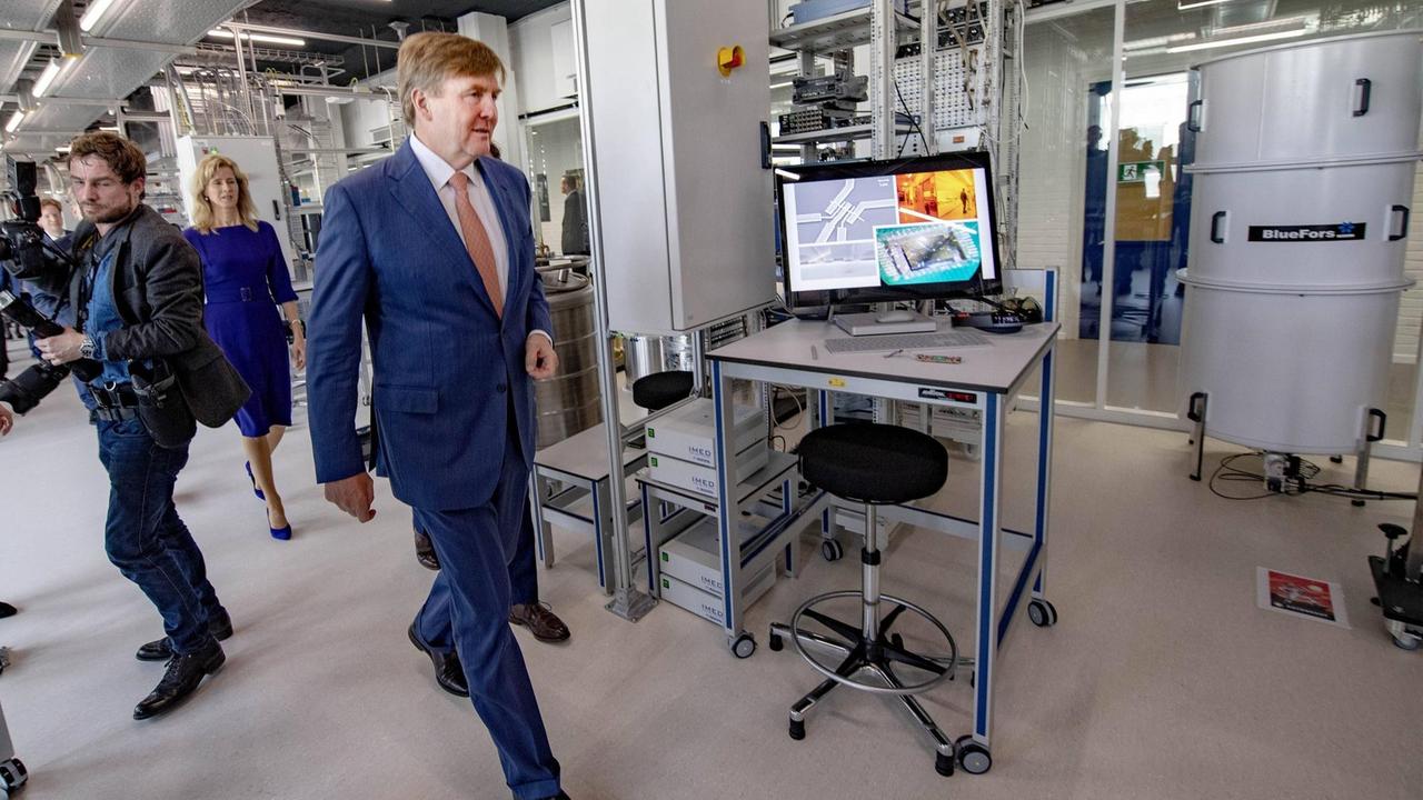 König Willem-Alexander bei der Eröffnung des Microsoft-Quanten-Labors an der TU Delft am 21.02.2019 Im Hintergrund ein Steuerungs-Monitor und ein Kühl-Container 