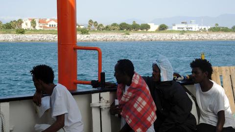 Migranten sitzen auf einem Boot 