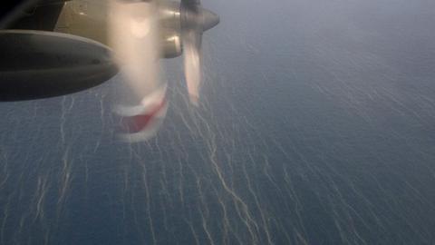 Ein Flugzeug überfliegt die Ölspuren auf dem Meer, die von der verschollenen Maschine stammen könnten.
