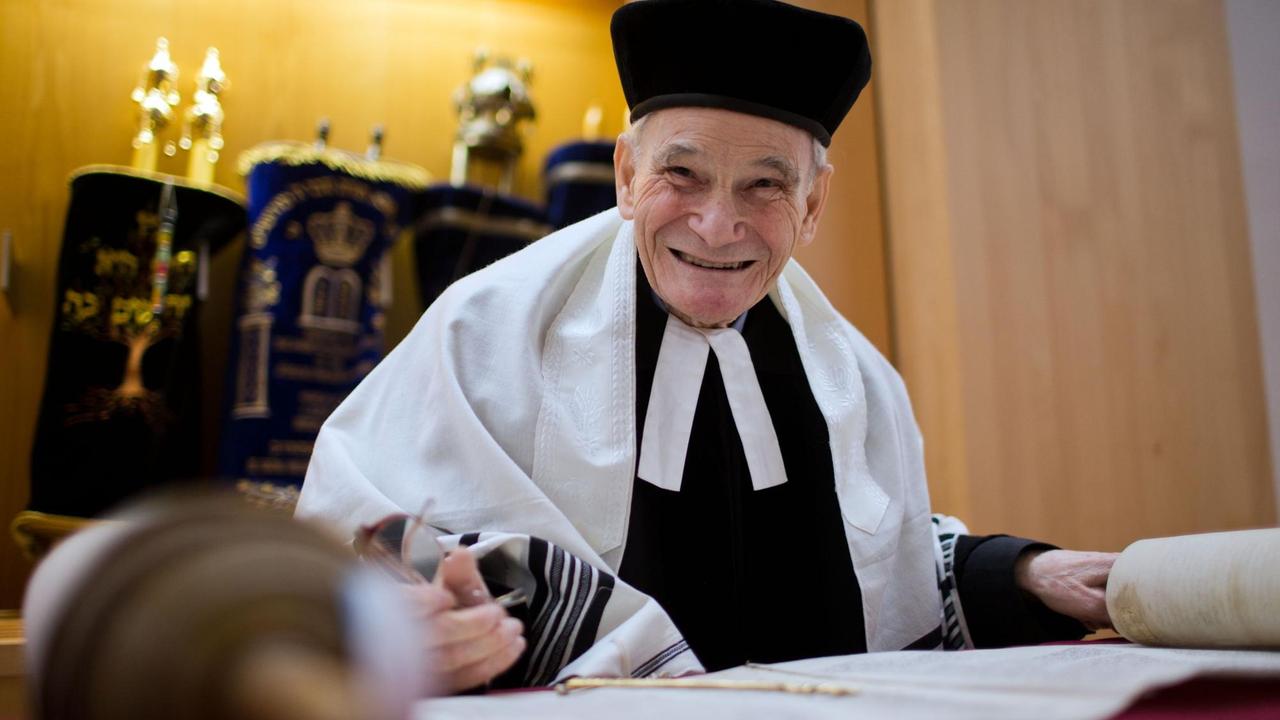 William Wolff, Rabbiner in Mecklenburg-Vorpommern, liest am 16. Januar 2014 aus der ausgebreiteten Tora in der neuen Synagoge von Schwerin. Der 86-jährige wurde am 27. Januar 2014, dem Tag des Holocaust-Gedenkens, zum Ehrenbürger der Landeshauptstadt ernannt.