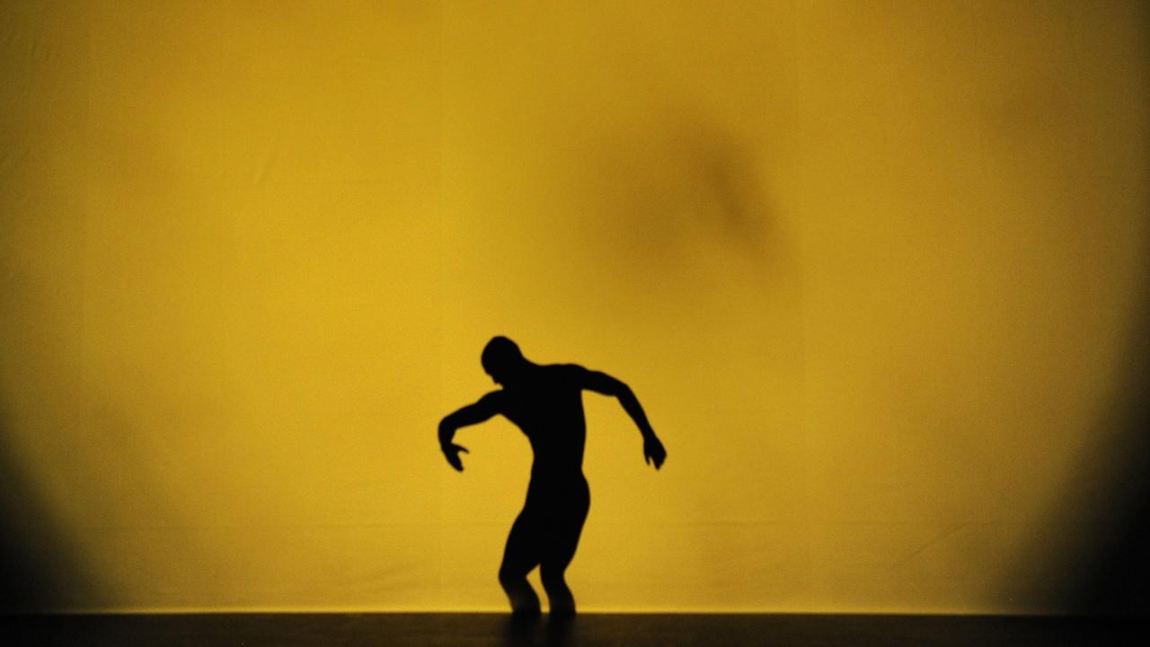 Modern Dance Performance: ein Mann vor einem großen gelben projektierten Fleck