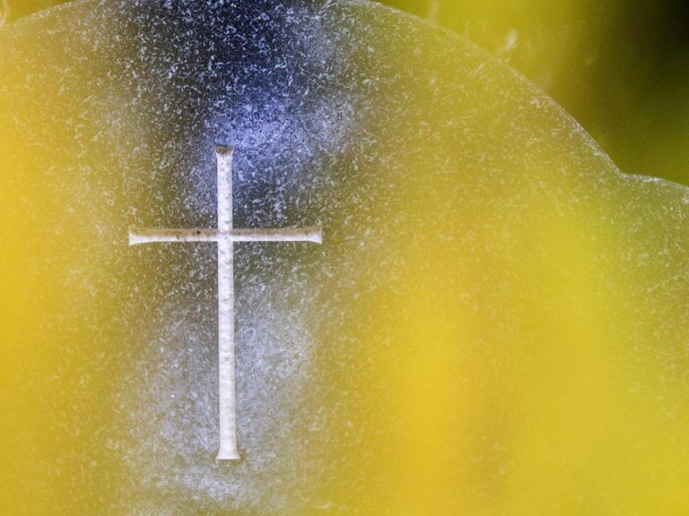 Ein Grabstein mit eingraviertem Kreuz.