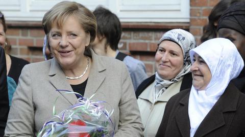 Bundeskanzlerin Angela Merkel (l) 2010 bei ihrem Besuch der "Bürgerinitiative ausländischer Arbeitnehmer" in Hamburg-Wilhelmsburg.