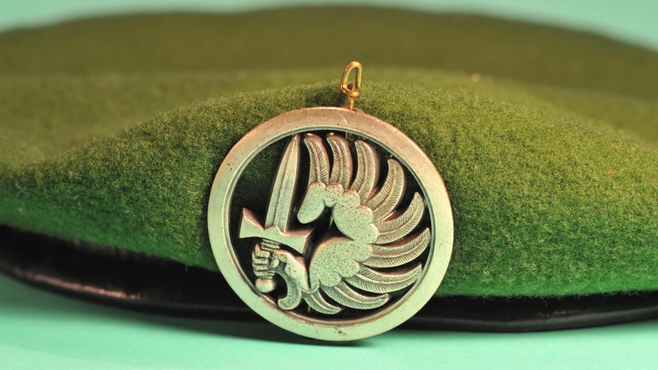 Emblem der Fallschirmspringer der Fremdenlegion an einem grünen Barrett 