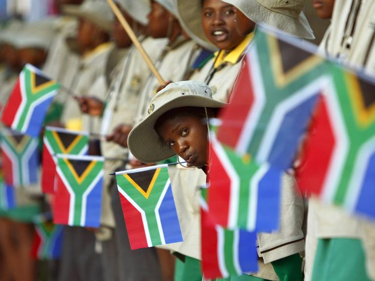 Südafrikanische Kinder (mit Flaggen) vor dem Parlamentsgebäude in Kapstadt.