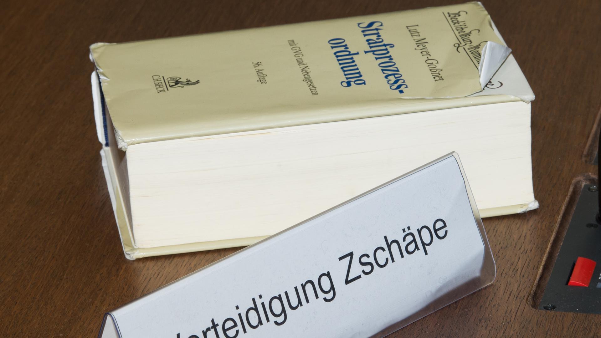 Ein Schild mit der Aufschrift "Verteidigung Zschäpe" steht am 15.04.2014 auf der Anklageband im Gerichtssaal im Oberlandesgericht in München.