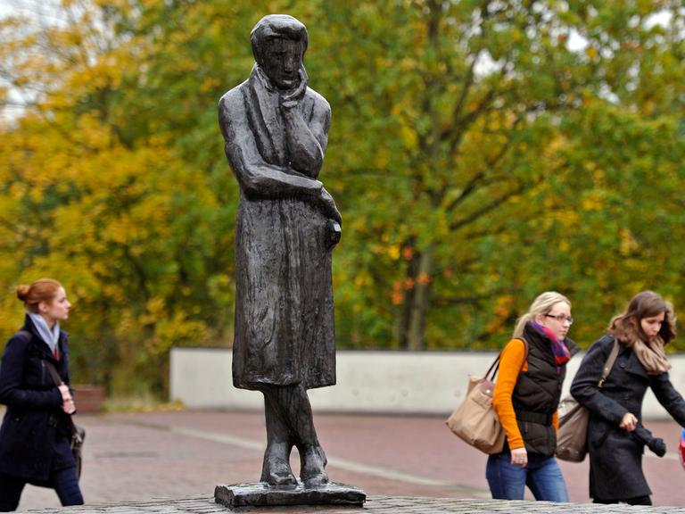 Frauen laufen am 16.10.2012 an einer Statue des Schriftstellers Heinrich Heine auf dem Gelände der Heinrich-Heine-Universität in Düsseldorf (Nordrhein-Westfalen) vorbei.