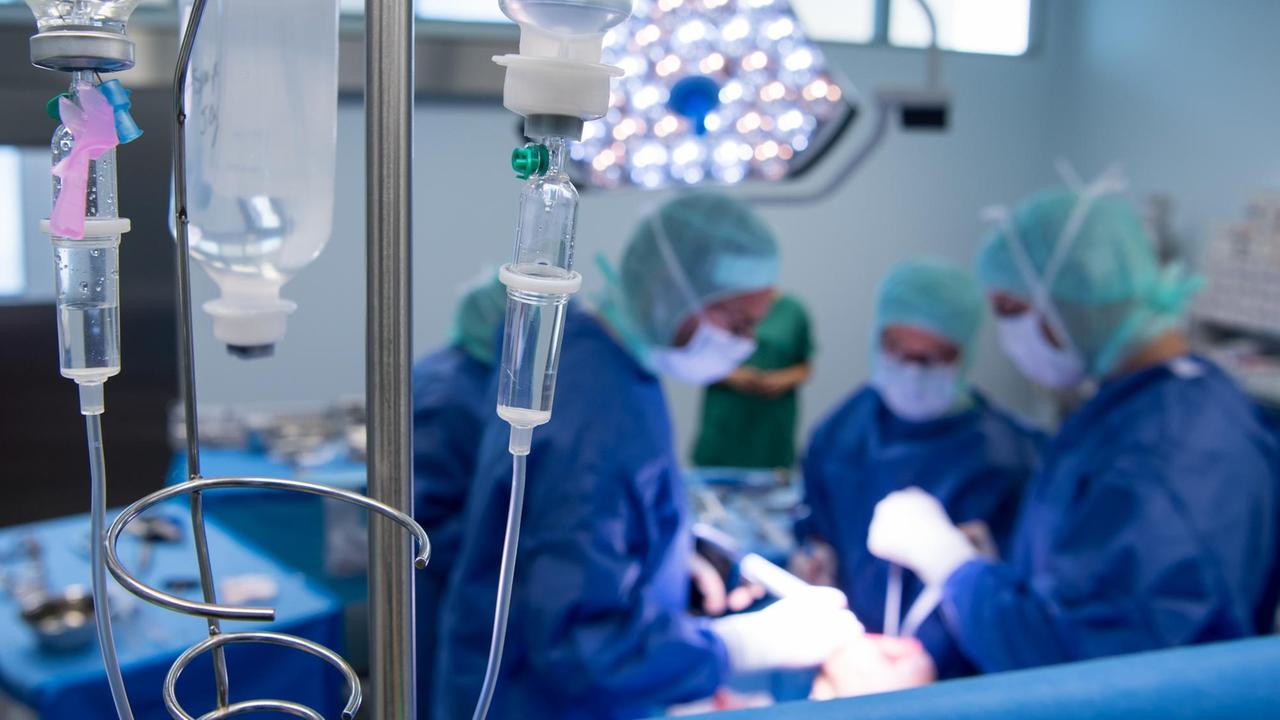 Blick in den Operationssaal: Ein Ärzteteam setzt einem Patienten während einer Knie-Operation eine Knietotalendoprothese (Knie-TEP) ein.