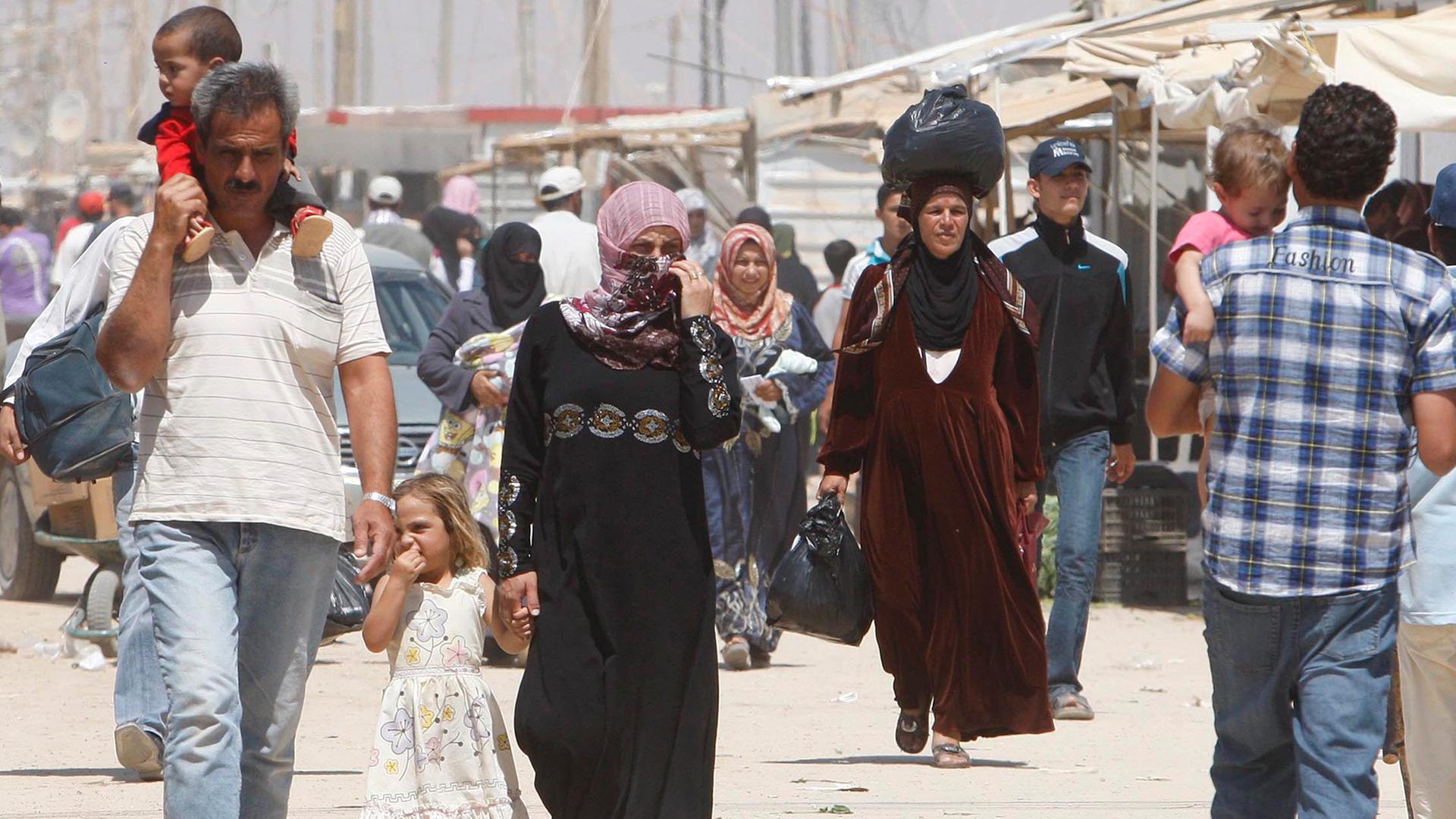 Syrische Flüchtlinge laufen im September 2013 über die Hauptstraße eines Flüchtlingscamps in Mafraq, Jordanien.