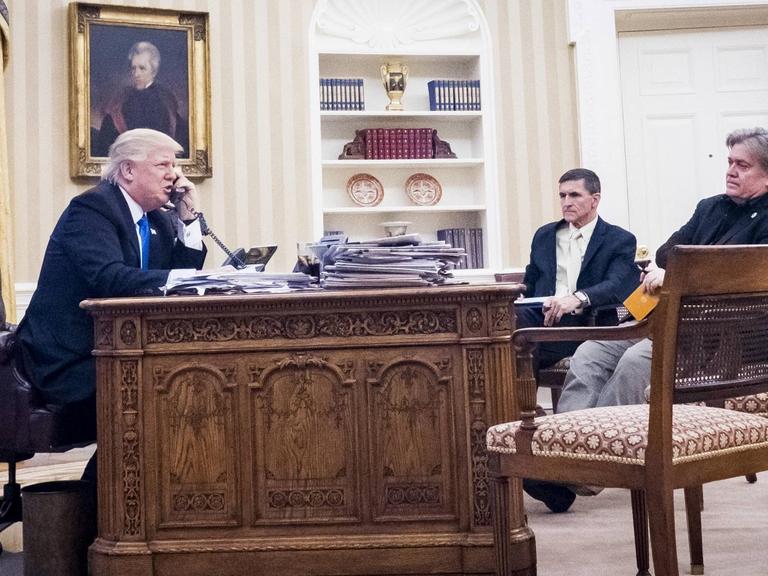 US-Präsident Donald Trump mit seinem Berater Stephen Bannon (rechts außen) im Oval Office, mit ihnen der inzwischen zurückgetretene Sicherheitsberater Michael Flynn