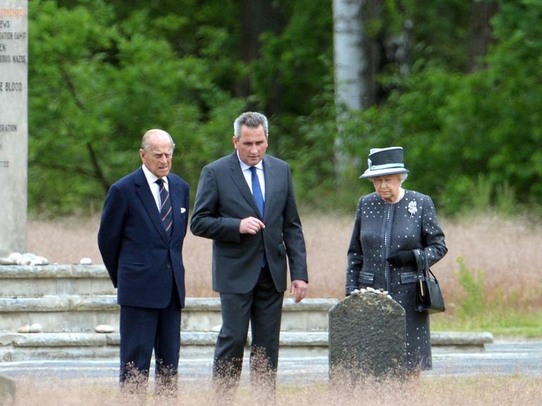 Elizabeth II. und Prinz Philip neben Jens-Christian Wagner, Direktor der Gedenkstätte Bergen-Belsen.