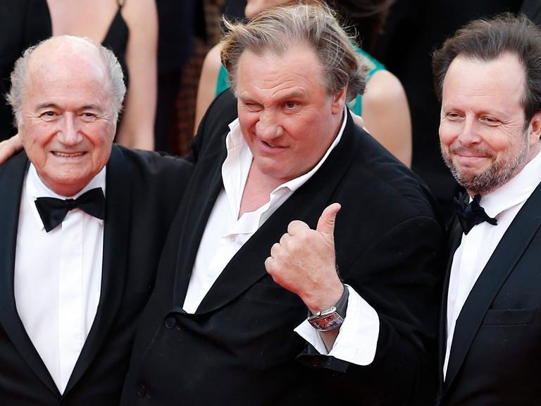 Schauspieler Gérard Depardieu lässt sich in Cannes mit FIFA-Präsident Sepp Blatter und dem Regisseur Frédéric Auburtin fotografieren.