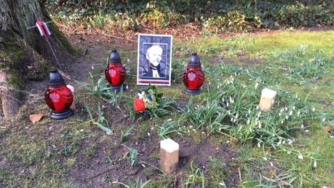 Ein Foto von Bischof Juliusz Bursche und einige Grablichter auf dem Friedhof Reinickendorf