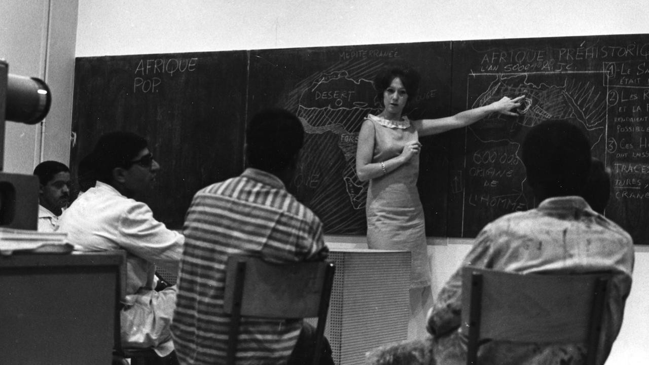 Die Dozentin Toni Maraini steht vor einer Tafel und unterrichtet in den 60er Jahren ihre Kunstgeschichtsklasse an der Ecole des Beaux-Arts in Casablanca, Marokko. Das Bild stammt aus einer pädagogischen Broschüre der Ecole de Casablanca, 1962-1965.