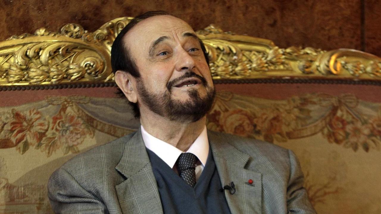Rifaat al-Assad bei einem Interview 2011. Er lächelt.