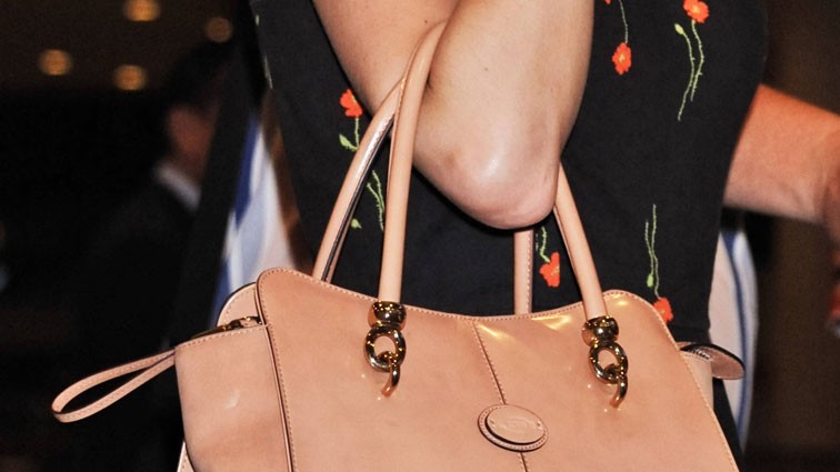 Nahaufnahme der Sängerin Taylor Swift mit ihrer lachsfarbenen Handtasche. Sie fliegt am 02.06.2014 am Flughafen Narita International aus Japan ab.