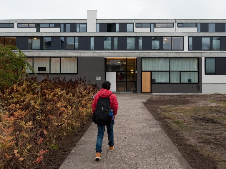 Ein Student geht zu Haus Neun des Studentendorfs Schlachtensee in Berlin. Das Haus wurde renoviert.