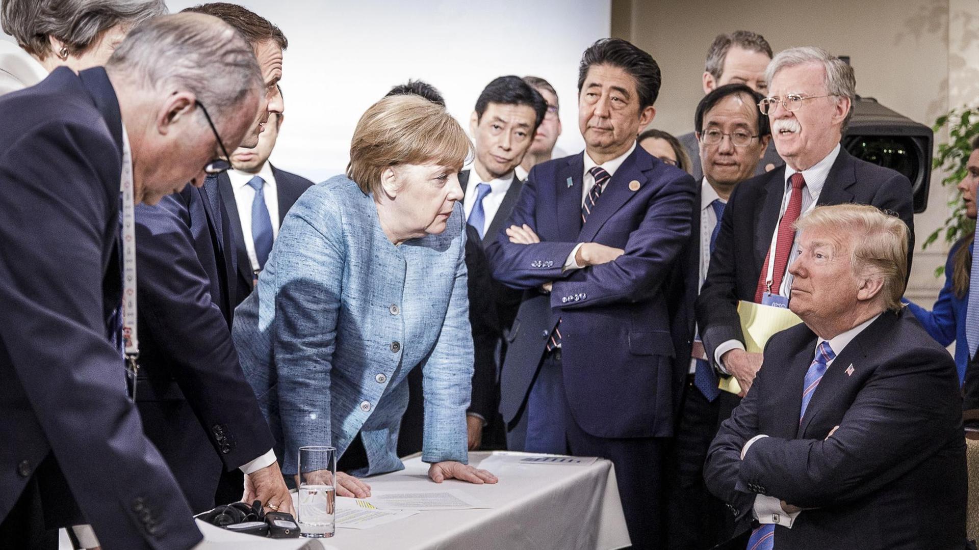 Merkel spricht mit Trump während Macron, Abe und Bolton zuhören.