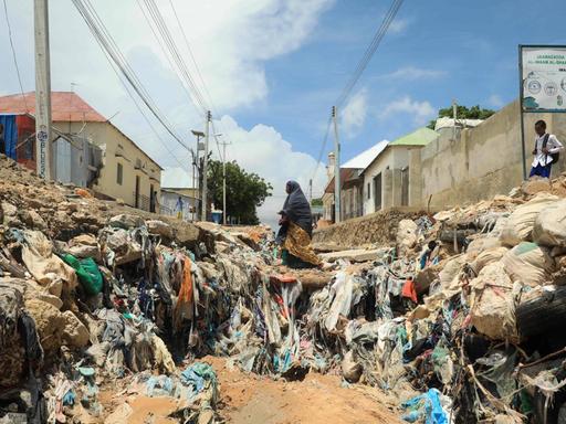 Eine Frau geht über eine zerstörte Straße in Somalias Hauptstadt Mogadischu