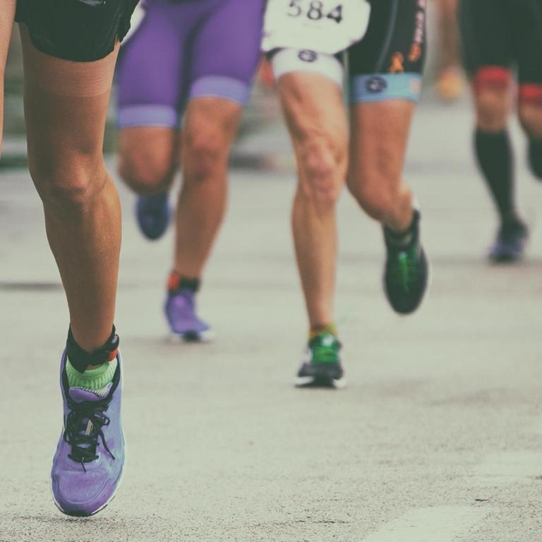 Die Beine einer Gruppe von Marathon-Läufern auf der Straße