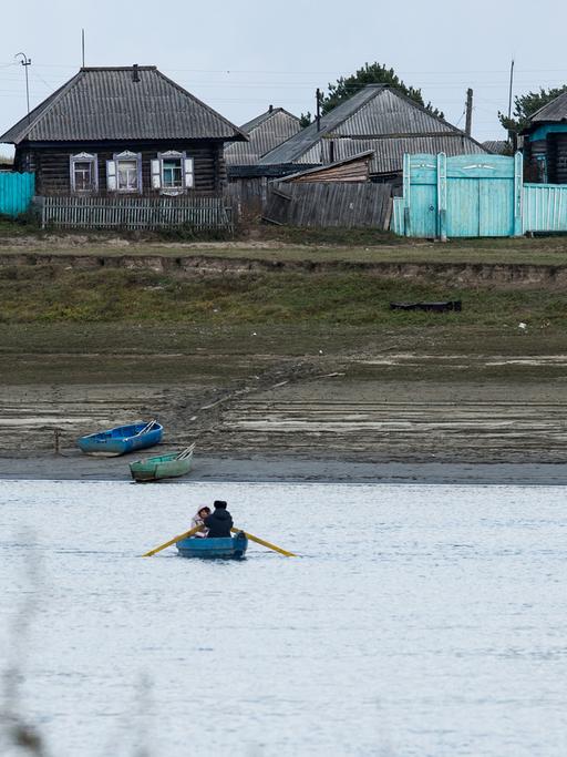 Ein Schüler wartet im sibirischen Omsk (Russland) auf ein Boot, das ihn über den Fluss bringt.