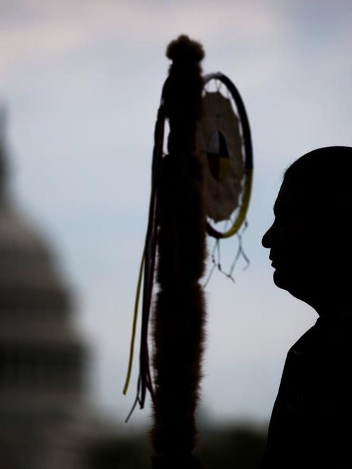 Matthew Black Eagle Man, Mitglied der Dakota Sioux Nation, wartet in Washington, DC, auf die Stammesführer der Cowboy and Indian Alliance, um gemeinsam mit einem Ritt zu Pferde gegen die Keystone XL Pipeline zu deomonstrieren. Im Hintergrund ist die Kuppel des Capitols zu sehen.