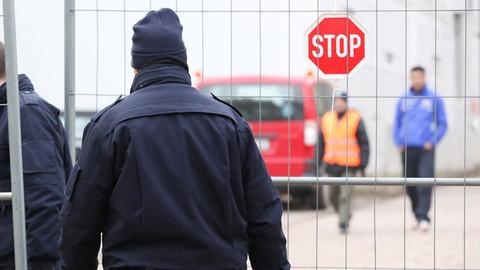 Mitarbeiter eines Sicherheitsdienstes gehen am 01.12.2014 auf das Gelände einer Flüchtlingsunterkunft in Hamburg-Bahrenfeld.