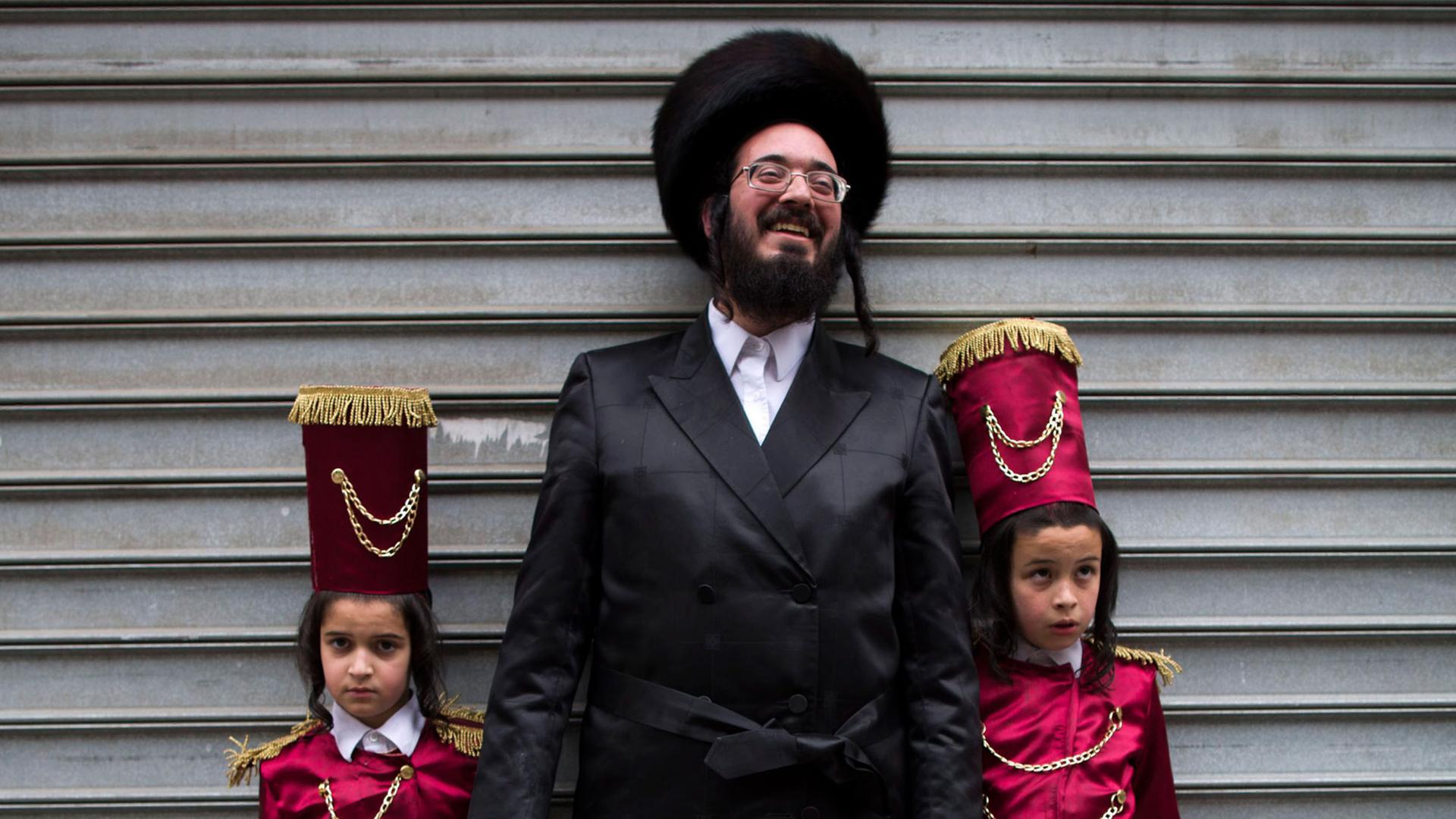 Jüdischer Vater mit seinen festlich gekleideten Kindern.