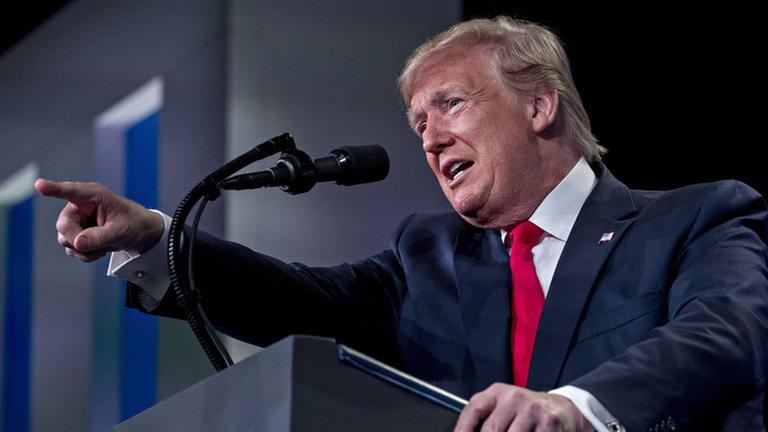 US-Präsident Donald Trump steht während eine Rede an einem Pult und zeigt mit dem Zeigefinger geradeaus.