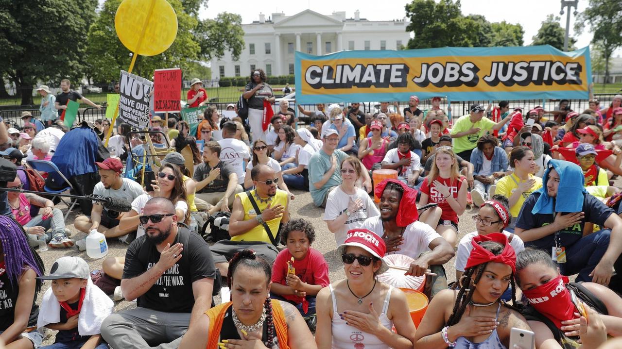Demonstranten sitzen in Washington auf einem Gelände in der Nähe des Weißen Hauses. Sie haben sich zu einem Klima-Marsch versammelt.