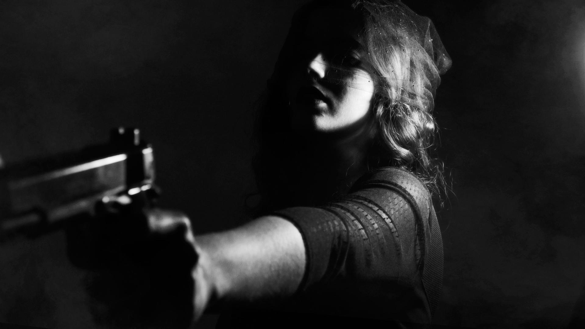 Eine Frau hält eine Pistole in der Hand.