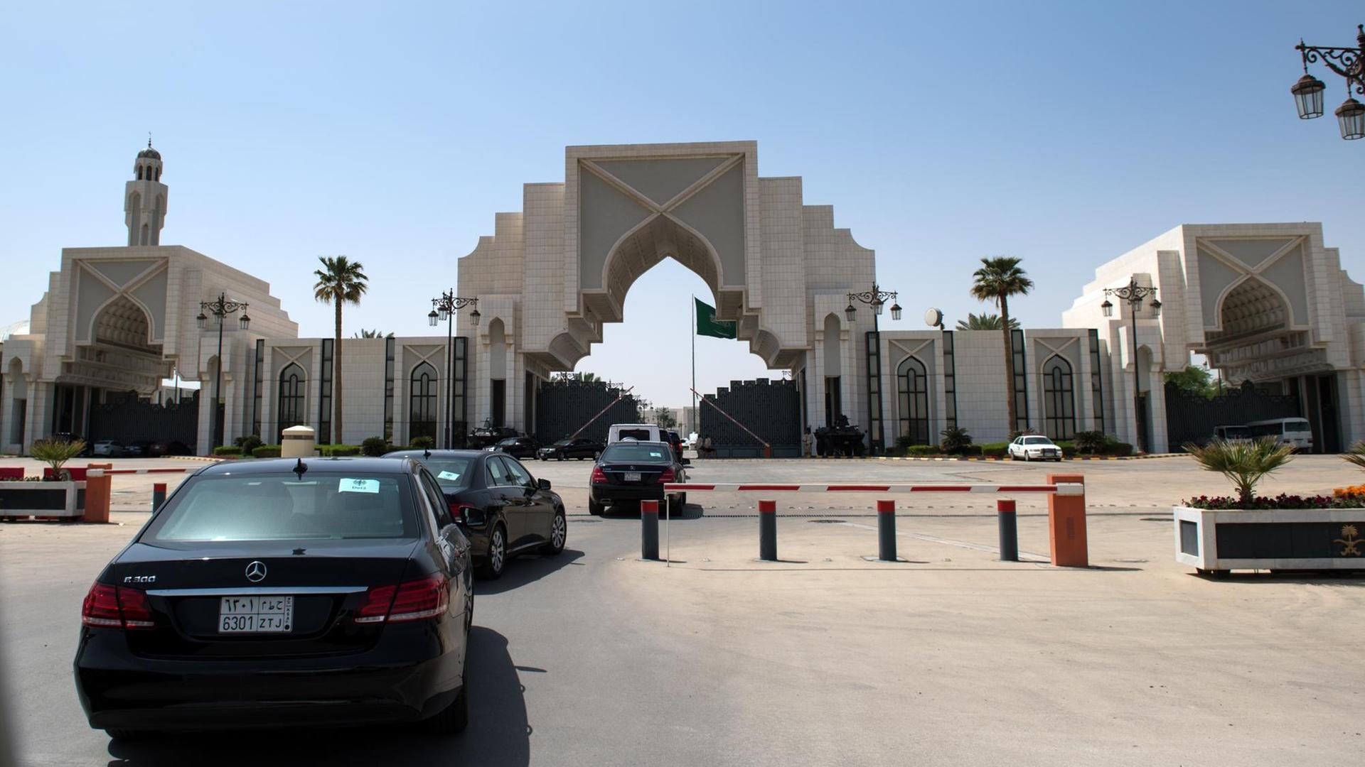Mehrere schwarze Autos fahren auf den Königspalast in Riad zu.