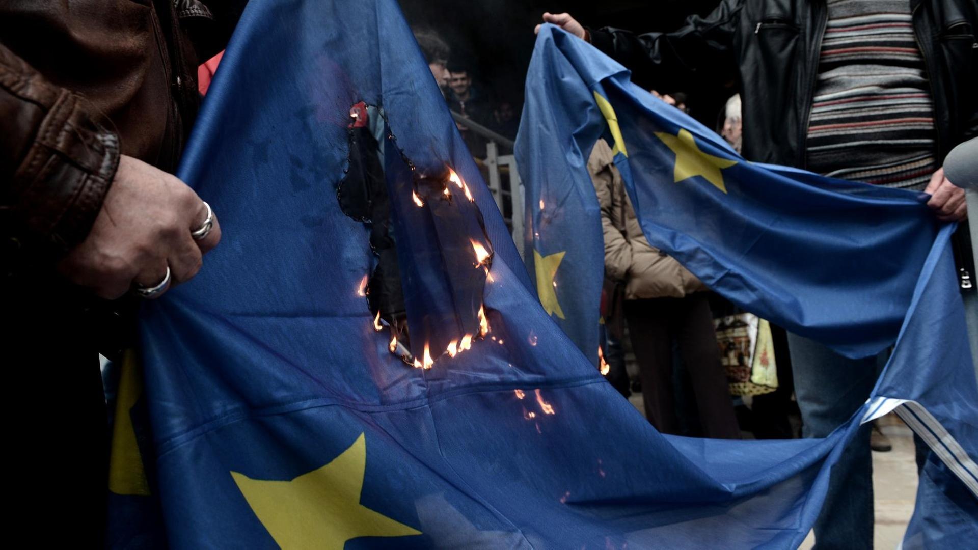 Demonstranten verbrennen eine EU-Flagge, als sie am 10. Januar 2018 vor dem Gerichtsgebäude in Thessaloniki gegen Versteigerungen von Immobilien protestieren.
