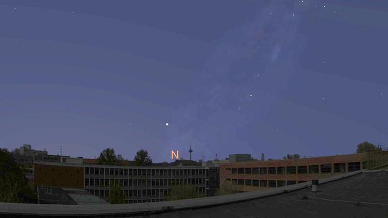 Der Stern Kapella steht um Mitternacht tief über dem Nordhorizont; am oberen Bildrand erkennt man den Polarstern.