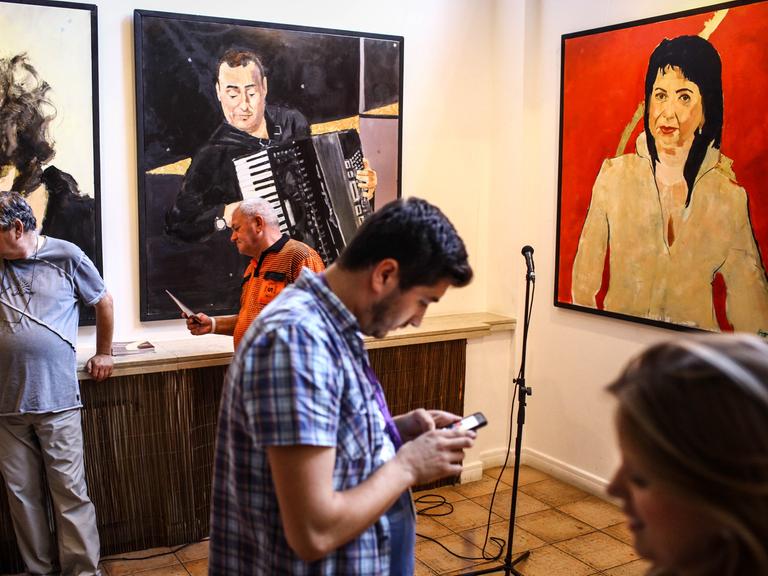 Besucher am 2.7.2014 bei der Eröffnung einer Ausstellung mit Bildern von George Vasilescu, die Sinti- und Romamusiker zeigen, im Museum des rumänischen Bauern, Bukarest.