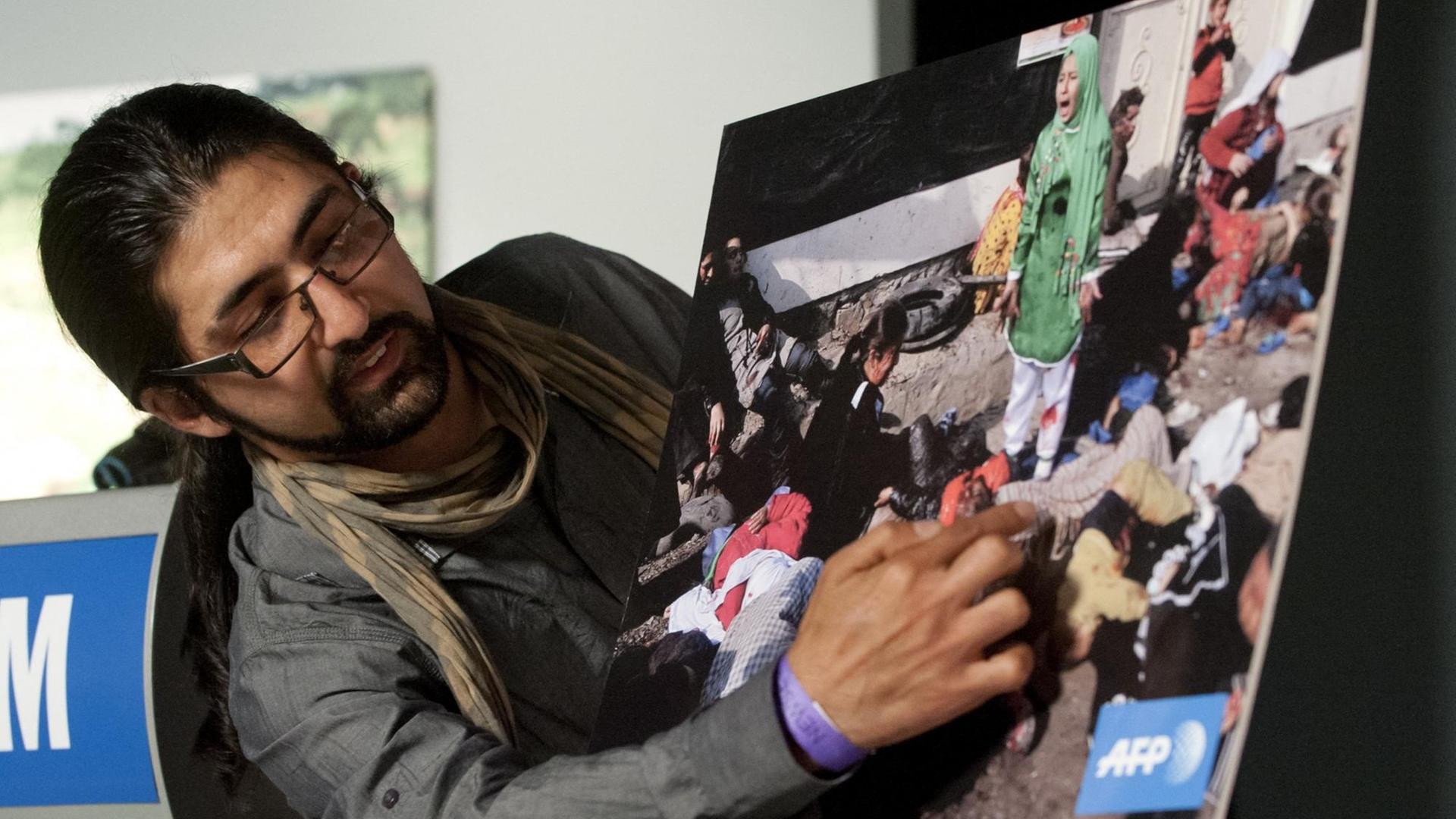 Der Fotograf Massoud Hossaini zeigt auf ein Foto, für das er mit dem Pulitzer-Preis ausgezeichnet wurde.