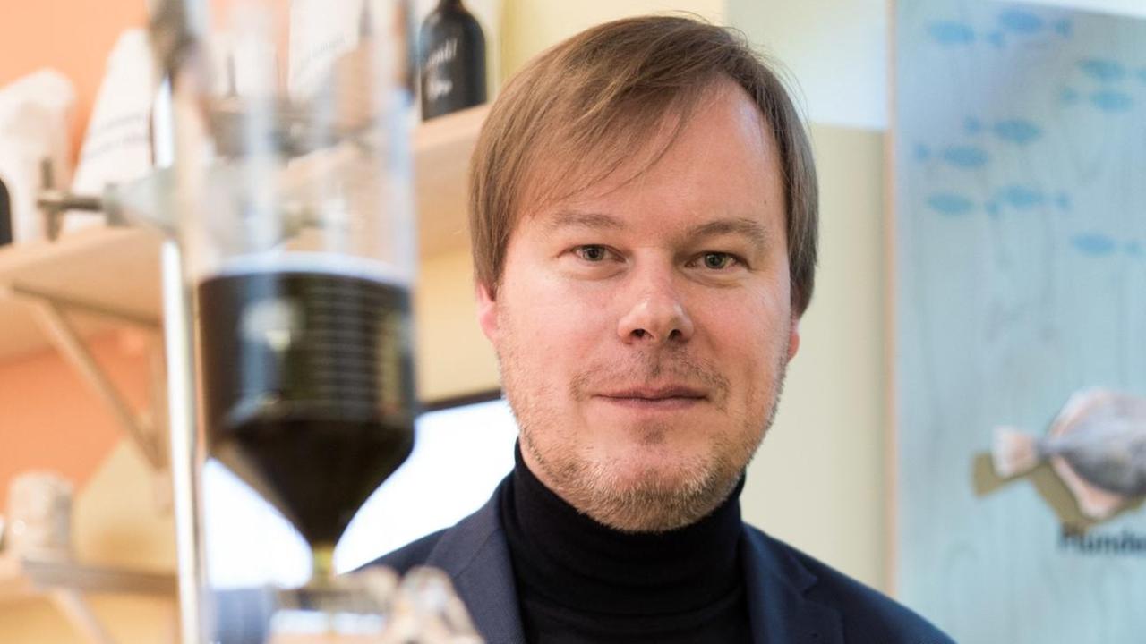 Der Wissenschaftler Andreas Kliemant sitzt an einem Tropftrichter auf der Grünen Woche am 20.01.2017 in Berlin und beobachtet wie ein Extrakt aus geriebenem Spinat, Wasabi und Pfeffer in ein Glas mit Rapsöl tropft und dieses dann die Farbe von Olivenöl annimmt.