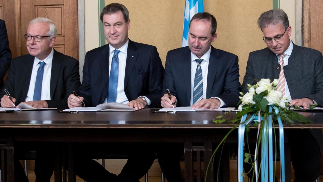 (v.l.) CSU-Fraktionschef Thomas Kreuzer, Ministerpräsident Markus Söder (CSU), Hubert Aiwanger (Landesvorsitzender Freie Wähler) und Florian Streibl (Parl. Geschäftsführer FW) unterzeichnen den Koalitionsvertrag.