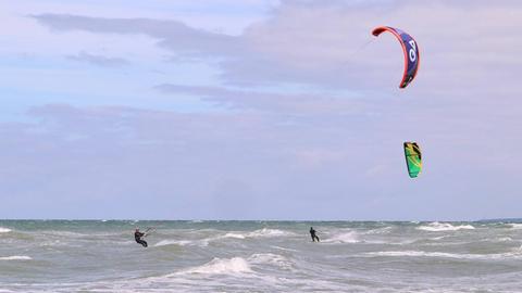 Kite-Surfer auf dem Meer. Beim Kite-Surfen lassen sich die Surfen von einem Drachen ziehen