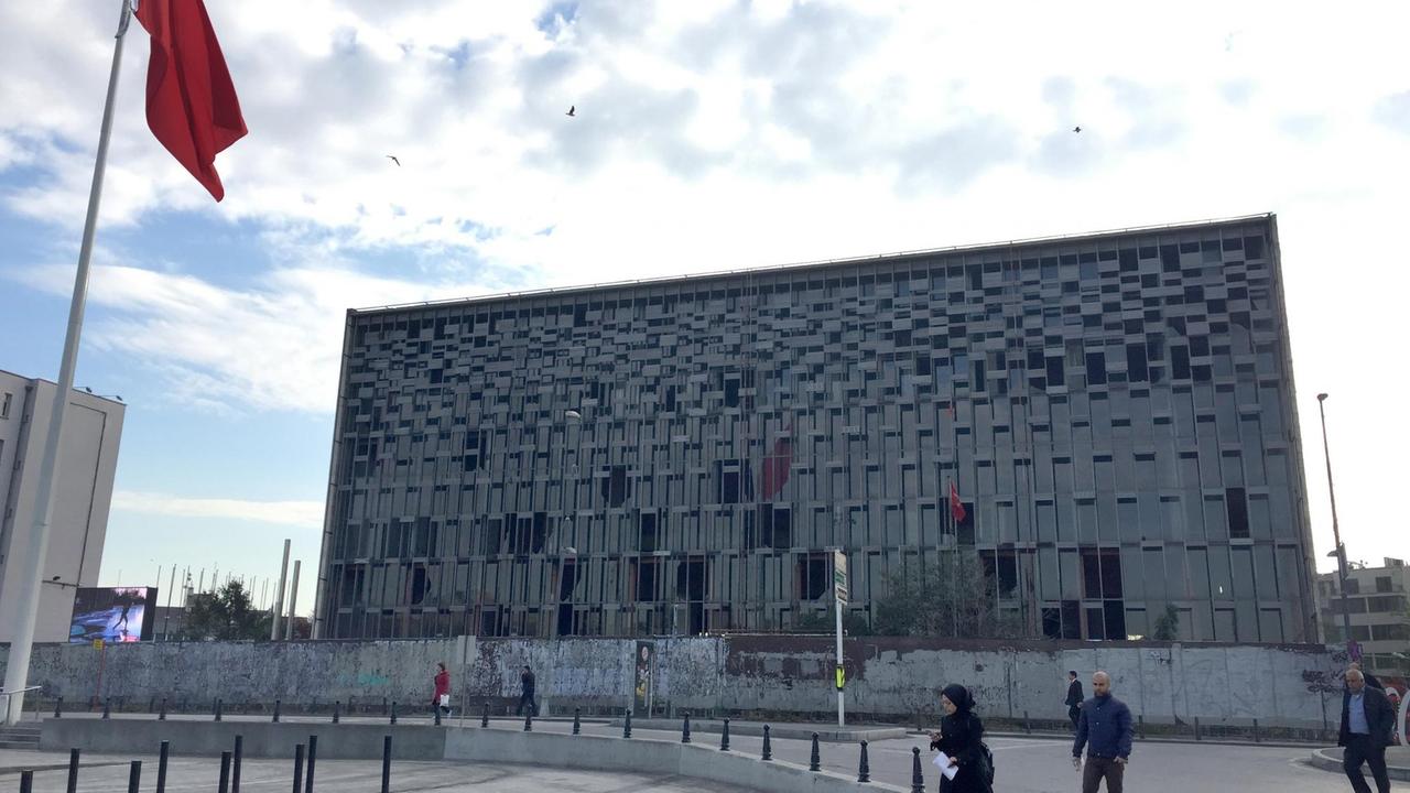 Das alte Atatürk-Kulturzentrum in Istanbul, daneben eine türkische Flagge.