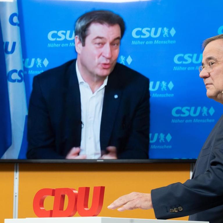 Armin Laschet, Ministerpräsident von Nordrhein-Westfalen und CDU-Chef, steht in einem Studio in Köln, während CSU-Chef Markus Söder zugeschaltet ist.